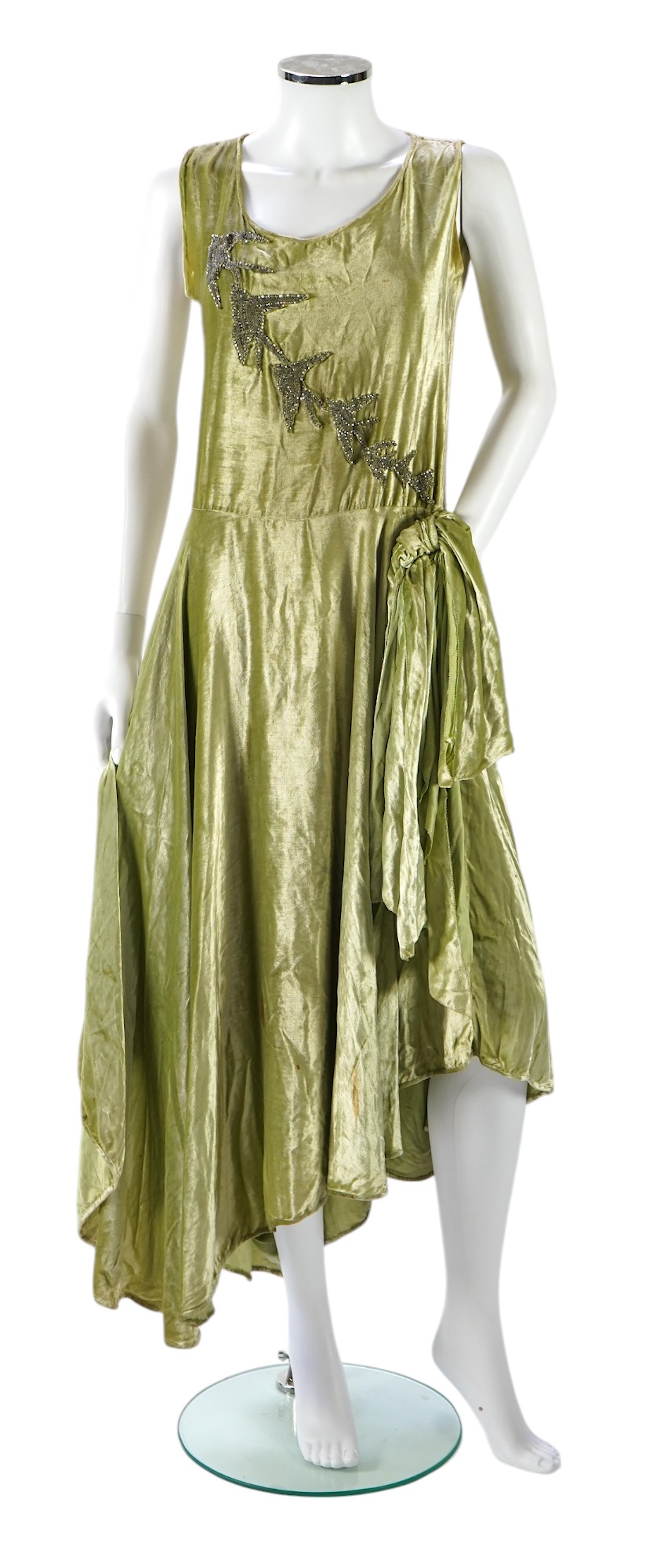 A late 1920’s early 30’s green panne silk velvet evening dress, bias cut, with large diamanté ornamentation and bow on the hip, bust 36 inches, length 55inches. Condition - there is a small hole on the front near arm hol